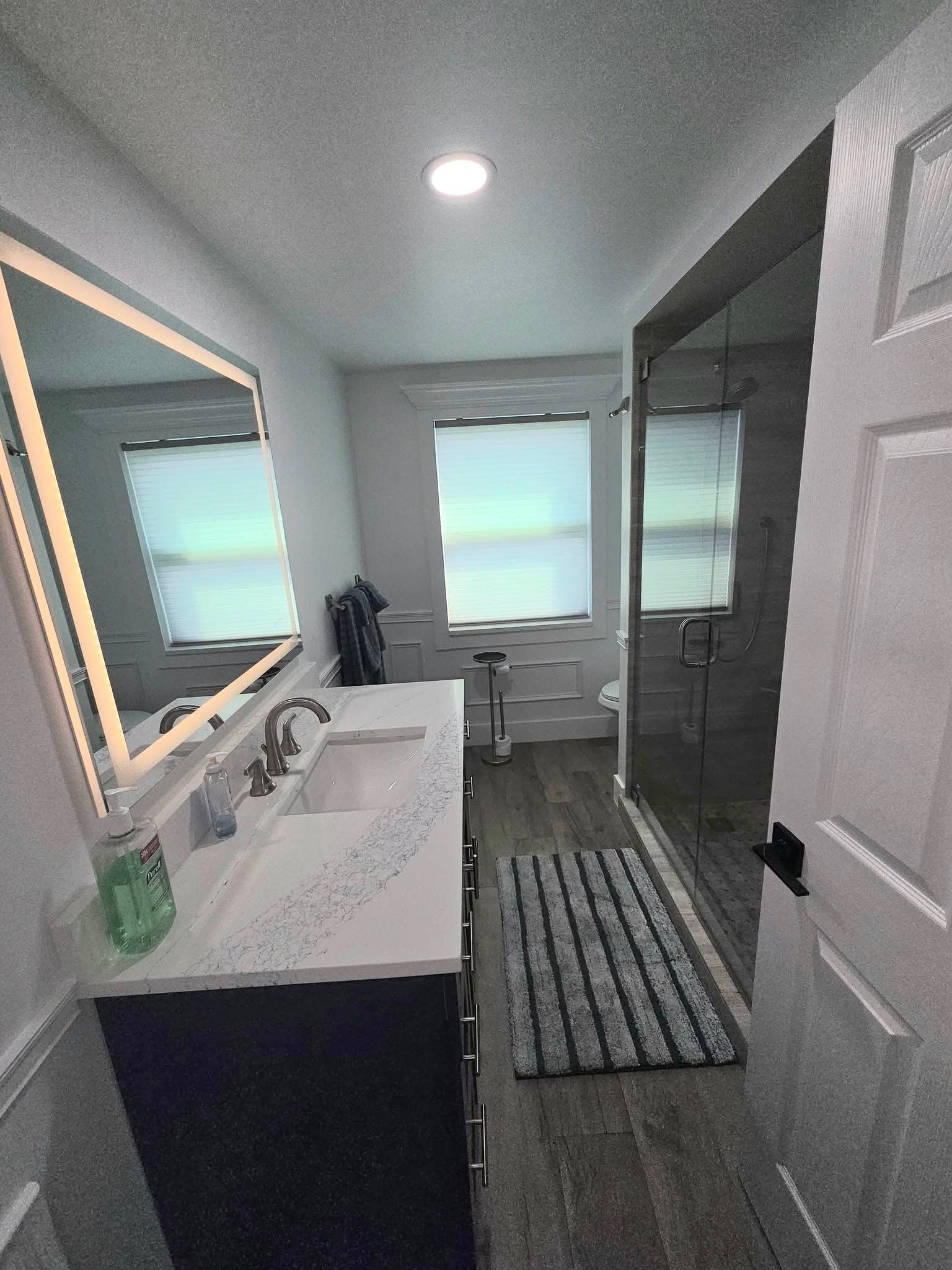 Bathroom with marble vanity and glass shower, freshly cleaned