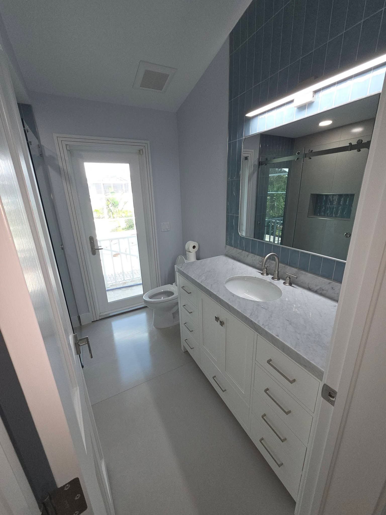 Pool bathroom with white vanity and blue tile after a clean