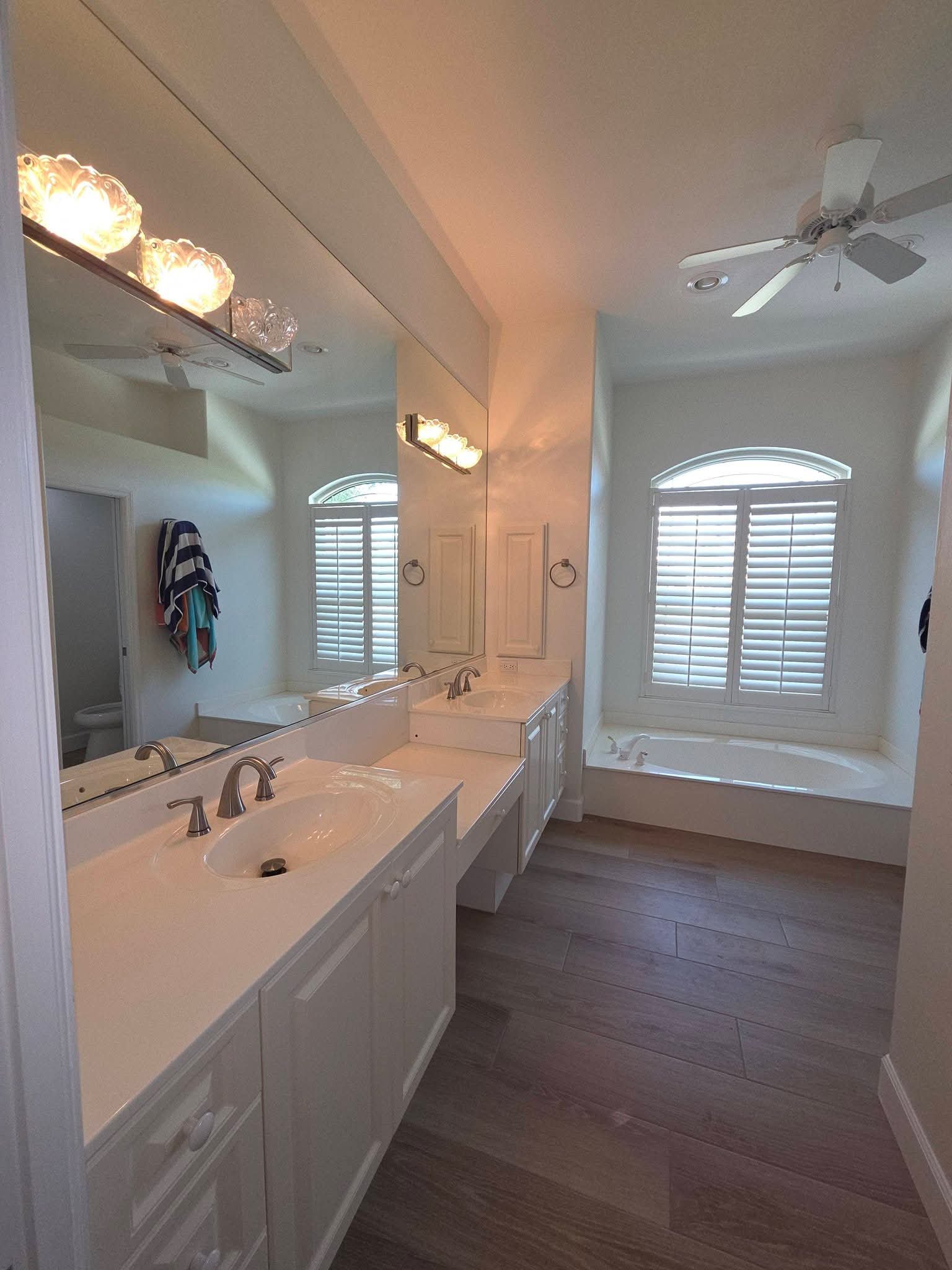 White bathroom with double sinks and soaking tub after cleaning