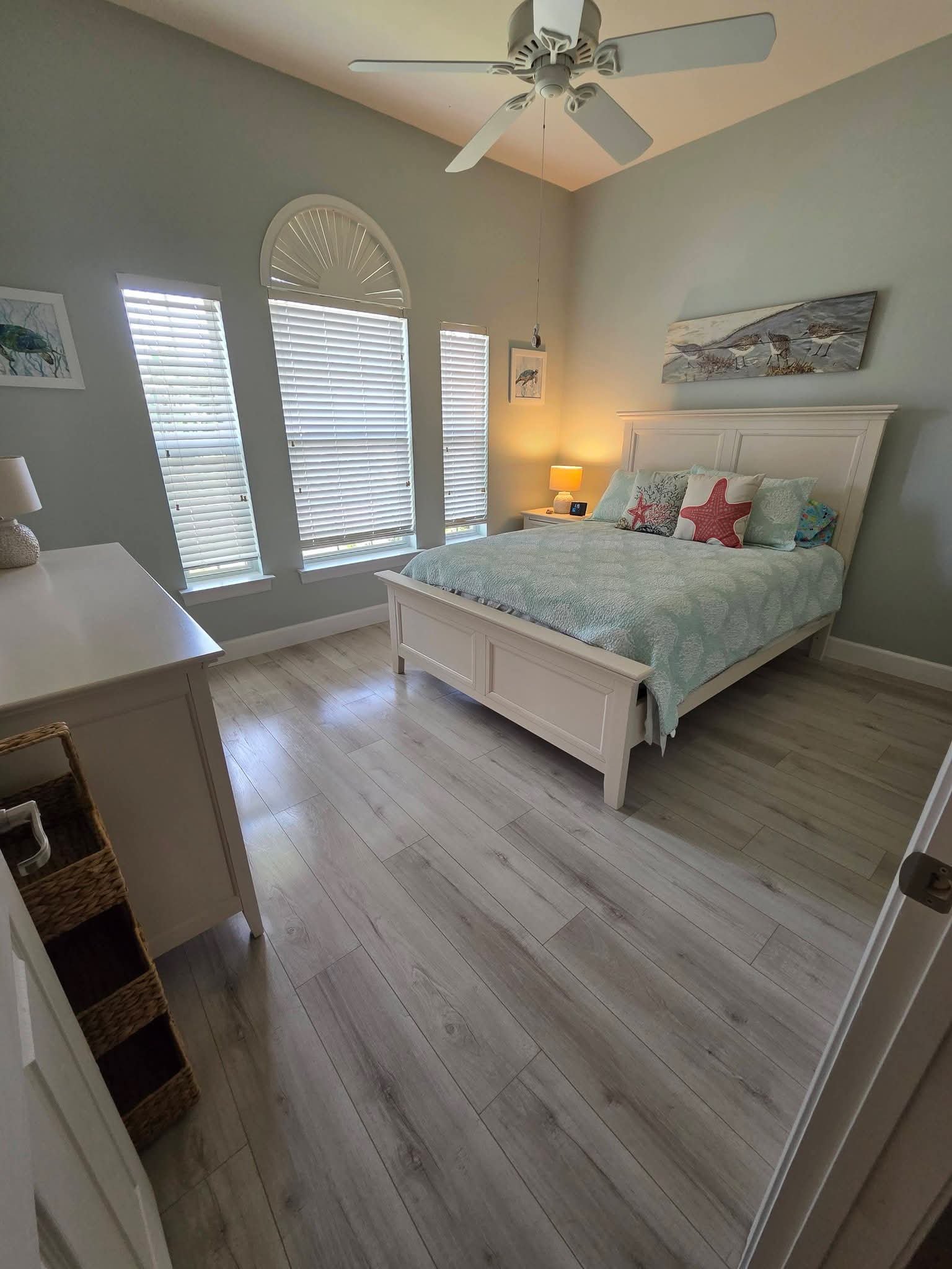 Coastal style bedroom with crisp linens and polished floors