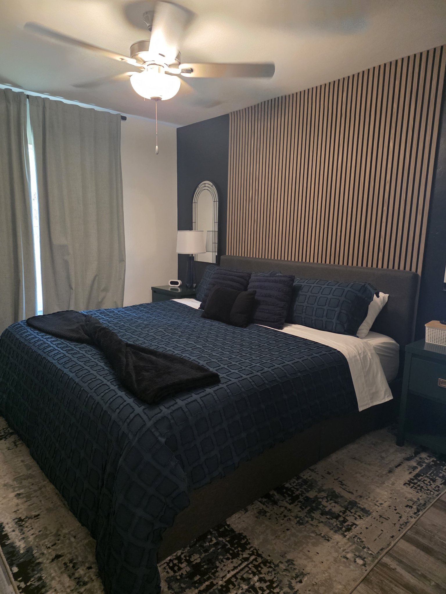 Spotless master bedroom with dark bedding after a deep clean