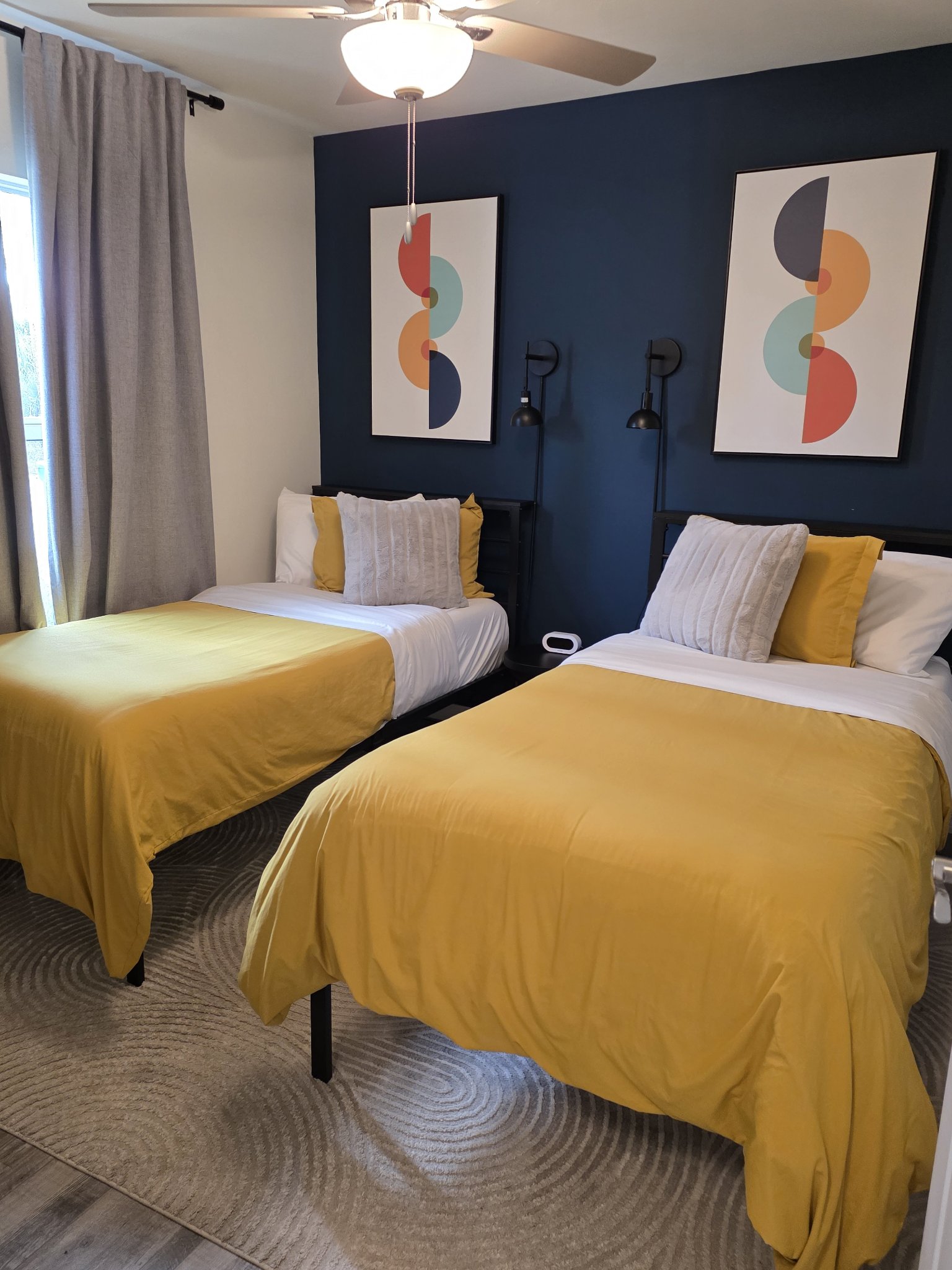 Freshly cleaned vacation rental twin bedroom with navy accent wall