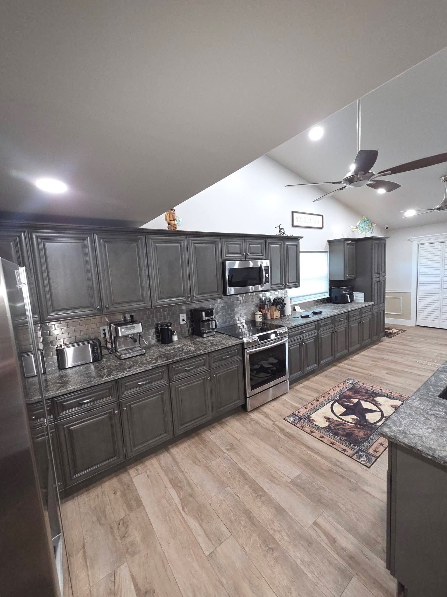 Kitchen with dark cabinets and stainless appliances, spotless after cleaning