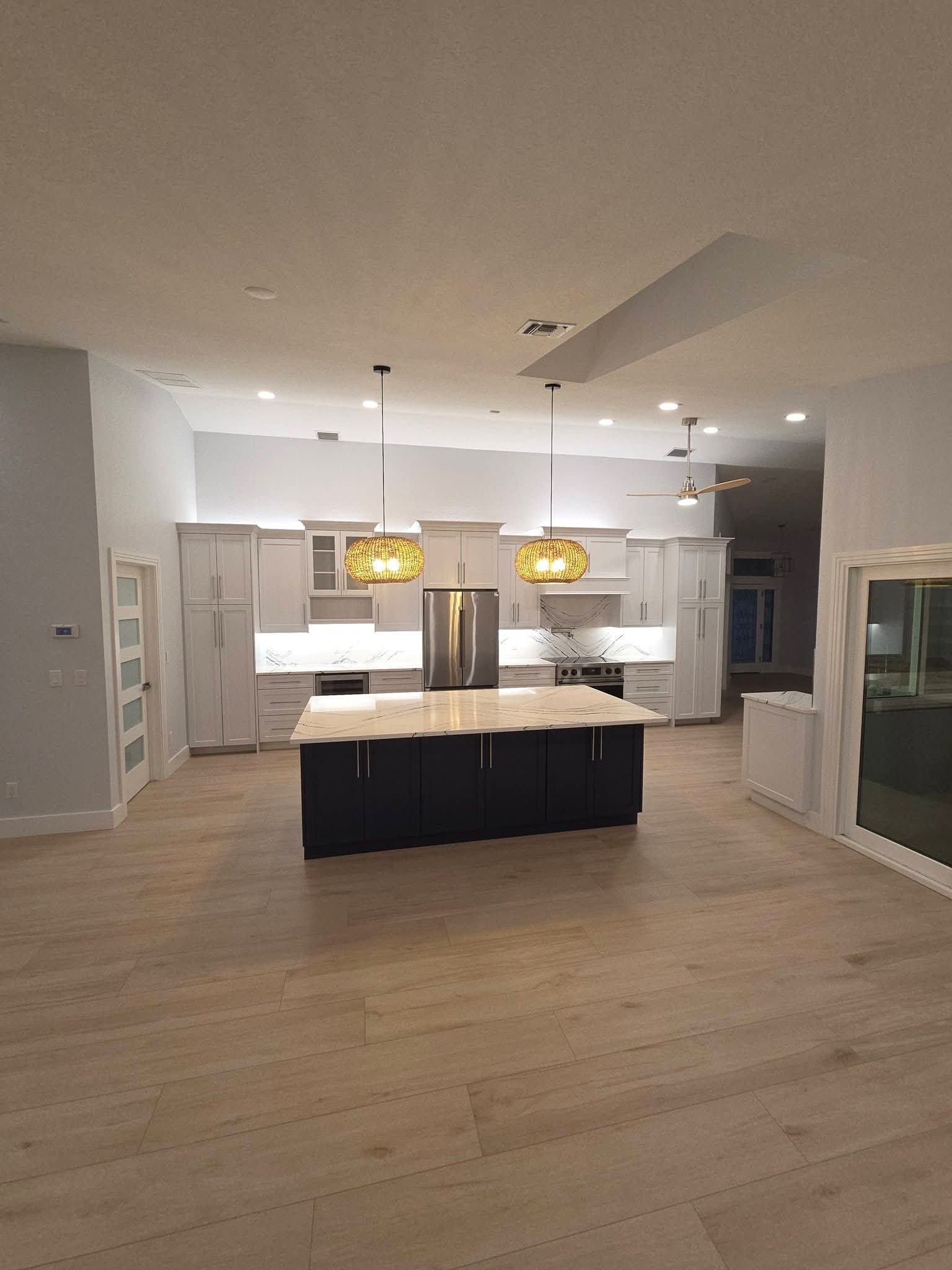 Bright white kitchen with marble island after a deep clean