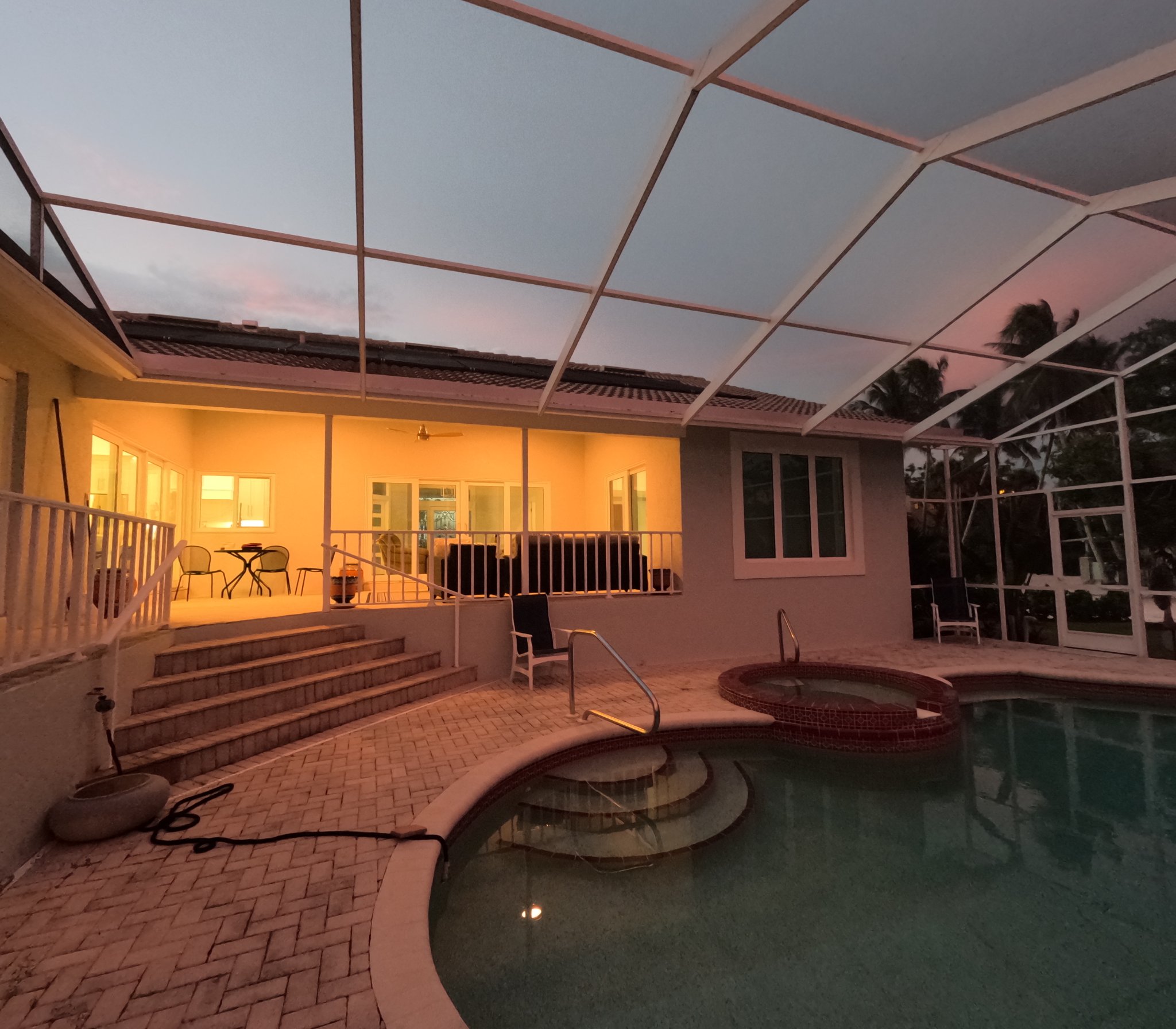 Florida pool and lanai at dusk, tidy and inviting
